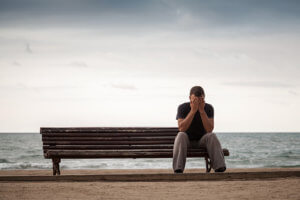 Man on Bench Overwhelmed With Heroin Addiction Symptoms