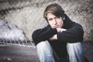 Young man sitting in the street thinking about the symptoms of heroin use