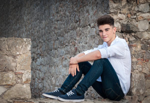 Young man sitting outside considering entering teenage drug rehab